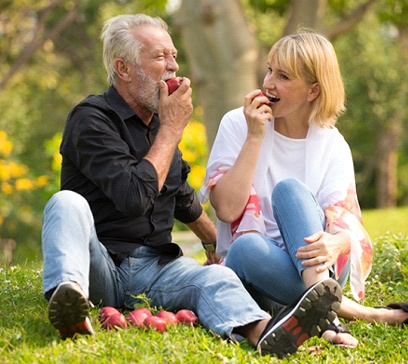 Older couple with dental implants in Bethel Park eating apples