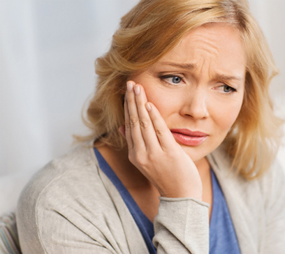 Pained woman looking worried about dental implant failure in Bethel Park 