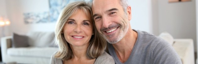 Man and woman smiling after dental implant tooth replacement