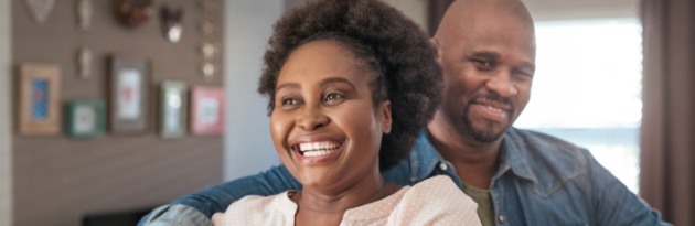 Man and woman smiling after surgical periodontal treatment